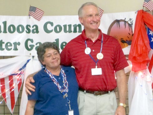 Outgoing Master Gardeners president Marge Stewart hugs 2013 president John Bauer, who received the Master Gardener of the Year award. Stewart received several recognitions including Outstanding Educator.