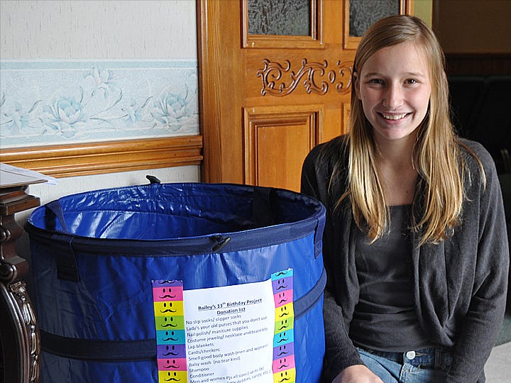 Railey Conner, 12, kneels beside a collection bin at First Baptist Church of Holt. Conner seeks the community's help in collecting gifts for senior citizens at area nursing homes.