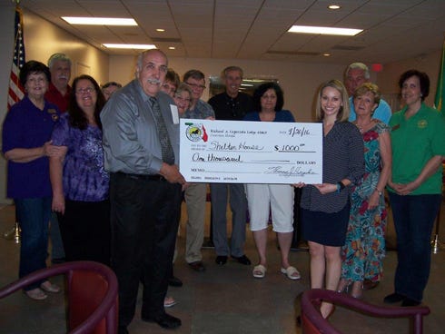 Members of the Sons of Italy in America Crestview lodge donated $1,000 to Shelter House April 20 at Foxwood Country Club. Group president Thomas Hughes (holding one side of the check, presented it to Rosalyn Iovieno of Shelter House (right, holding check). The group will also give the organization $500 a month through 2016.