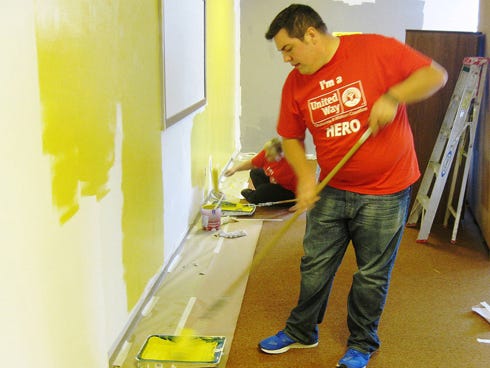 Whataburger's Brandon Diamond and Teri Reinhardt help paint Crestview Manor’s arts and crafts room during the United Way Day of Caring in Crestview.