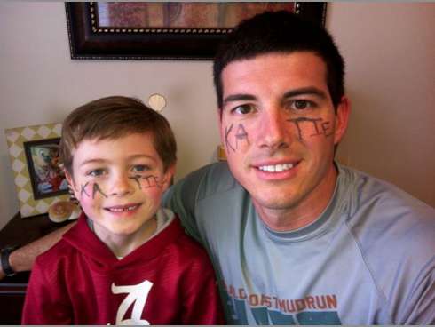 Daniel Richards — pictured with his son, Caleb, 6 — is running a mile or more in his "55 days of inspiration" to commemorate people with cancer. Katie Mitchell, whose name is written on the Richards' faces, is recovering from leukemia.