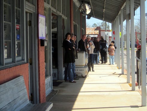 People socialize on the Baker Block's front porch during Baker Mercantile's re-opening. A Lunch on the Porch event is scheduled 8 a.m. to 3 p.m. June 21.