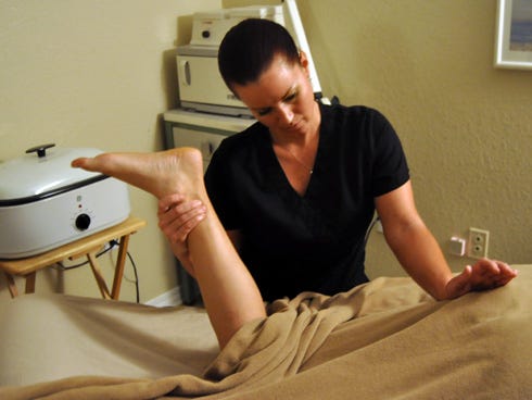 Shoshanna Richardson, a massage therapist at Hello Beautiful in Crestview, works on salon owner April Linton's leg after a back massage. Linton says she gets a monthly massage to prevent lower back pain.