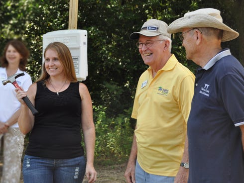 Crestview resident Stephanie Deese, holding the hammer, takes part in Habitat for Humanity of Okaloosa County's Wednesday groundbreaking ceremony. Deese, a single mother of two sons, is one of two Crestview recipients of affordable housing. To the left of Deese are construction managers Bill Prescott and Bob Hauge.