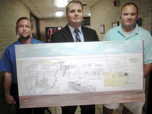 Main Street attorney Brad Stewart, center, flanked by artist Darryl Davis, left, and contractor Jeremy Stewart, displays a rendering of a mural planned for the side of Brad Stewart's law firm.