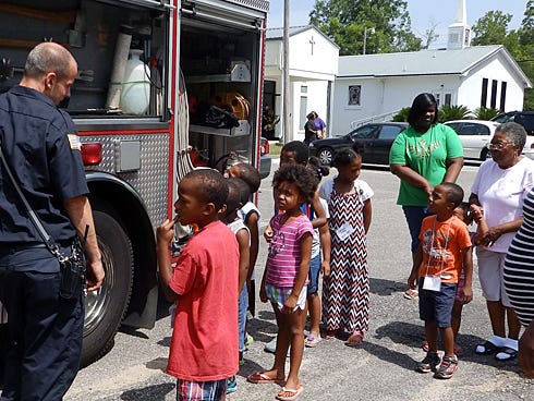 Children participating in the Lillie M. Conyers Summer Reading Program gather around Engine 1 on Tuesday outside Mount Zion AME church in Crestview.