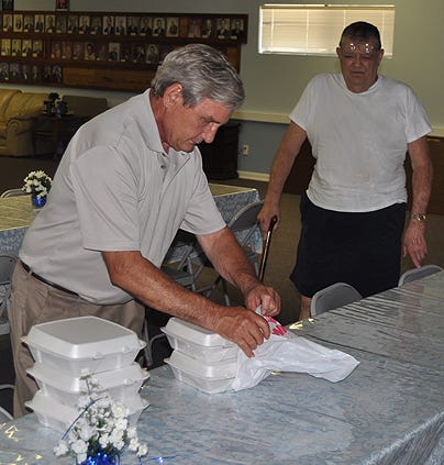 Rick Mouer, with the Okaloosa Scottish Rite Club, stacks to-go boxes of barbeque sandwiches for Dewey Harris on Friday at the Masonic Center. The club raised nearly $1,900 with a lunch benefit for the Childhood Language Disorders Clinic at Baptist Hospital Speech Center in Pensacola.
