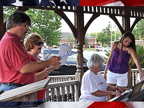 Kevin Lusk and Keitha Bledsoe sing while Bonita Clark plays the keyboard, with Megan Hutchinson's assistance, during the nationwide simultaneous singing of the national anthem on Saturday at the Veterans Memorial in Crestview.