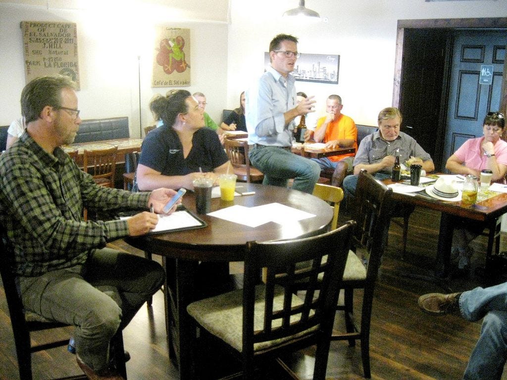 Downtown attorney Nathan Boyles, standing, addresses a gathering of business owners during the organizational meeting of the Main Street Merchants Association.