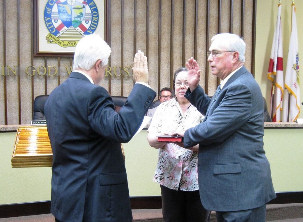 First Judicial Circuit Court Judge Michael Flowers swears in Doug Faircloth as Crestview's newest City Councilman as Administrative Services Director Teresa Gaillard holds the Bible.