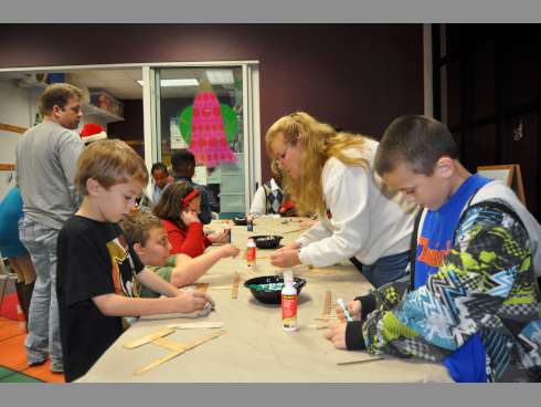 Ashton Crawford, 9, left, and his brother, Caleb, build replica kinaras, candle holders used to celebrate Kwanzaa, during the 10th annual Noel Night on Thursday at the Crestview Public Library.