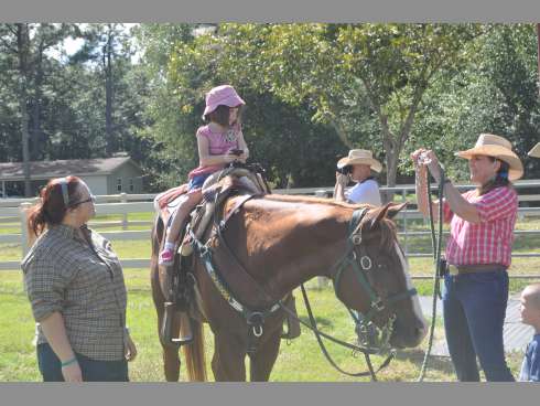 Rebecca Cartwright, left, stands beside her 4-year-old daughter Carina Cartwright, riding horseback, on Sunday at Old Warrior Ranch.
