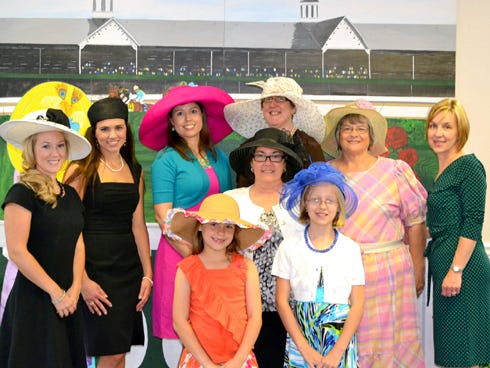 Spree and Tea attendees, from left, Casey Moorman, Kacy Kellogg, Dr. Kara Brooks, Jennifer Forehand, Charlotte Smith, Melissa Bracewell, Regina Moorman, center, Addie Brooks, 7, and Madison Forehand, 9, pose before a Churchill Downs backdrop painted by former Laurel Hill School art teacher Sabine Lyons.