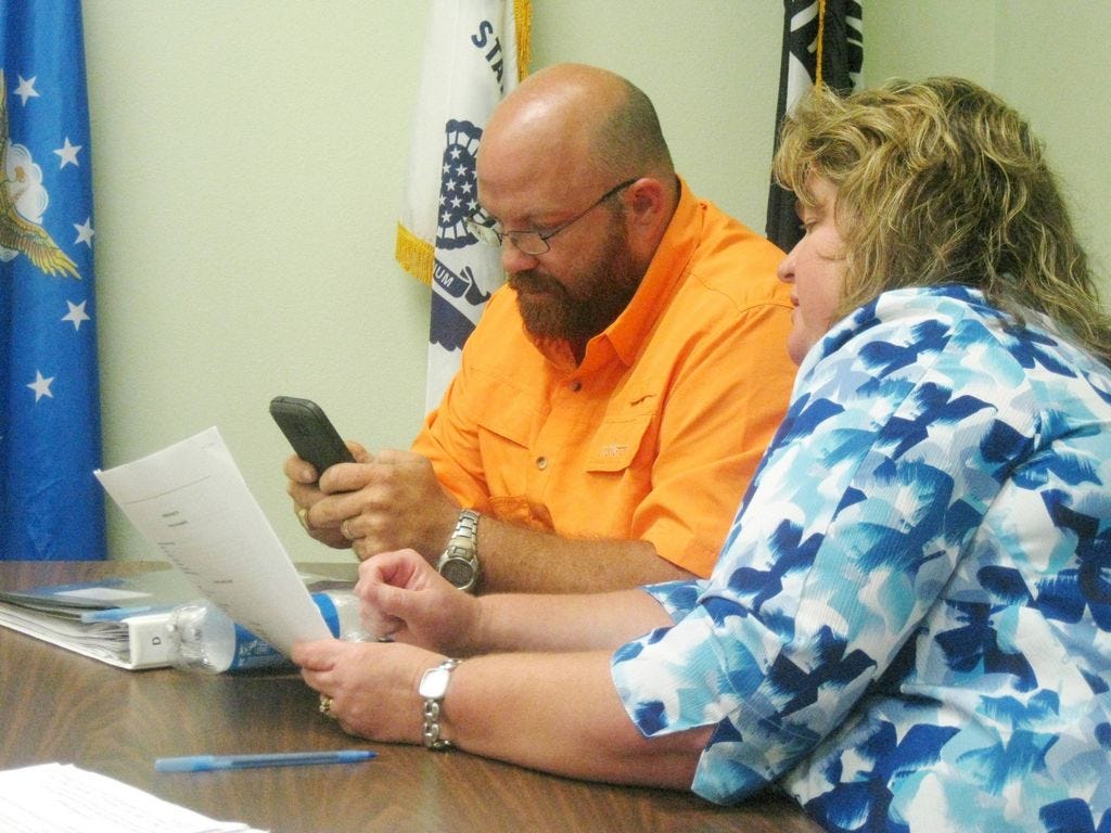 Laurel Hill City Council members Travis Dewrell and Debra Adams check property descriptions on the property appraiser's website to assure Johnny James's property description on the site and in his deed match.