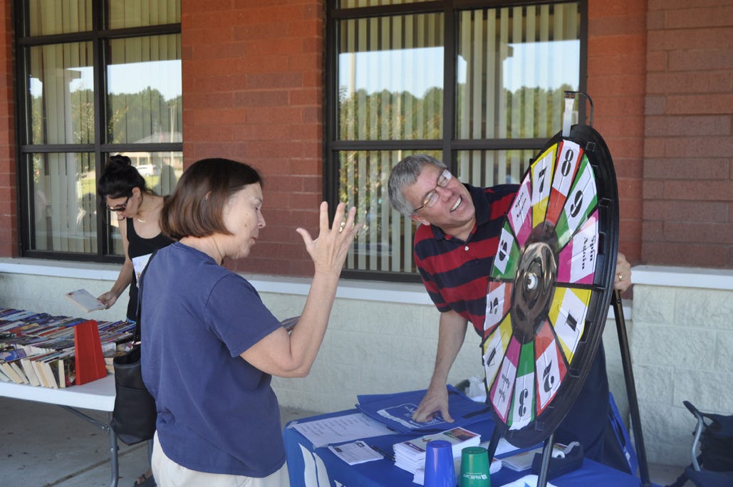 Sandra Turinc plays a “spin the wheel” game with WellCare representative Tom Ashton during the Information and Resources Fair on Saturday at the Crestview Public Library.