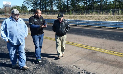 Ozzy Moya, Robert Brown and Jim Knight inspect the 1/8-mile track at the old Emerald Coast Dragway in Holt. Moya and Brown plan to renovate and re-open the drag strip. Baker resident Knight used to race his Ford Mustang at the park before it closed in 2011.