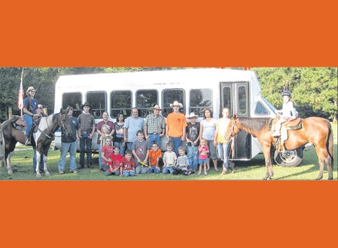 Ropin' the Truth ministry representatives stand beside their new bus, purchased with monetary donations.