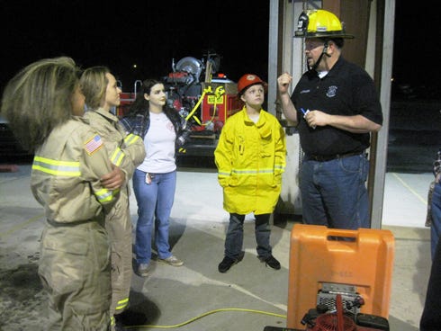 Baker Fire District Junior Firefighters Ariel Peterson, M.E. Cates, Bayne Burgess and David Kimbrell receive a safety briefing from program coordinator Lt. Mark McKenzie before joining senior firefighters on a drill.