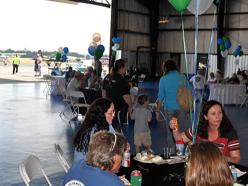 Visitors eat food in a hangar Saturday during the Emerald Coast Aviation's annual Fly-In at Bob Sikes Airport.