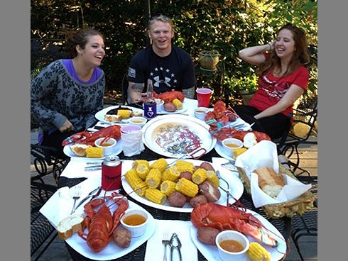 Crestview attorneys Muncelle Mitchell and Ashley Rogers share a laugh with Sgt. Derek Gibson during his farewell lobster feast.