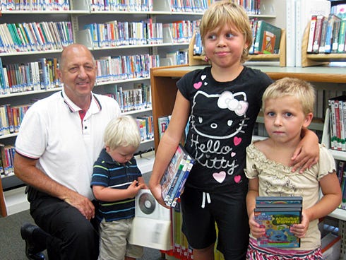Mark Christiansen says he regularly brings his grandchildren Torin, 2, Athena, 9, and Sonny, 5, to the library. “We come about every week to get movies,” Mark said. “We have for years.”