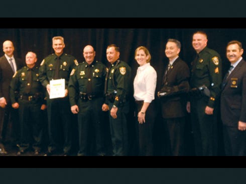 Okaloosa County Sheriff's Office employees accept their accreditation notice from Commission on Accreditation for Law Enforcement Agencies officials. Pictured from left are CALEA Executive Director Craig Hartley Jr.; Inspector Bob Norris, OCSO accreditation manager; Okaloosa Sheriff Larry Ashley; Major Greg Gaddis, OCSO operations bureau chief; Lt. Jay Jones, OCSO judicial services commander; Roberta Holloway, OCSO training coordinator; Capt. Ron Gay, OCSO Office of Professional Standards commander; Sgt. Matt Harrison, OCSO Judicial Services supervisor; and CALEA Commission Chairman Richard Myers.