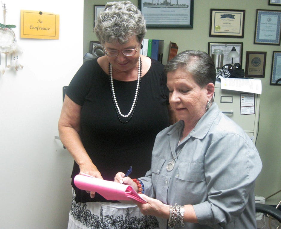 City Clerk Betsy Roy and Friends of the Arts President Rae Schwartz discuss plans for the July 11 dedication of the Warriors Hall flag display.