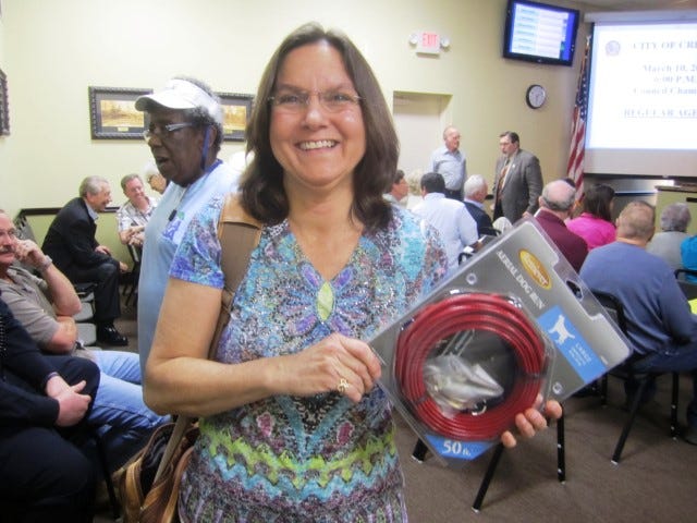 Dr. Jean Mitchell displays a pet trolley kit she recommends as a tethering alternative for residents without fenced-in yards.
