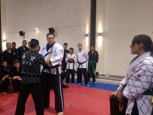 Tom Gordon, owner of Gordon Martial Arts in Crestview, demonstrates a sweep, or take-down, technique and waits for the Spanish translator, right of picture, to relay information to a group attending training in Guadalajara, Mexico.