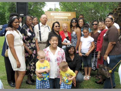 Annie Carroll Jackson’s family smiles in front of the North Okaloosa Historical Association’s Family Heritage Wall of Honor.
