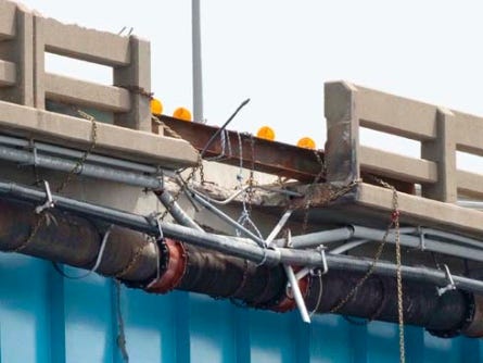 Part of the Brooks Bridge’s concrete barrier wall and sidewalk were still missing Thursday. The ruptured water pipe under the bridge had been repaired.
