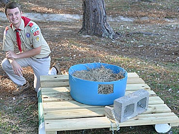 Austin Boyd poses next to one of six floatable duck nests that city officials installed on Monday afternoon at Twin Hills Park. Boyd built the nests with help from church volunteers, Troop 731 members and the city of Crestview.