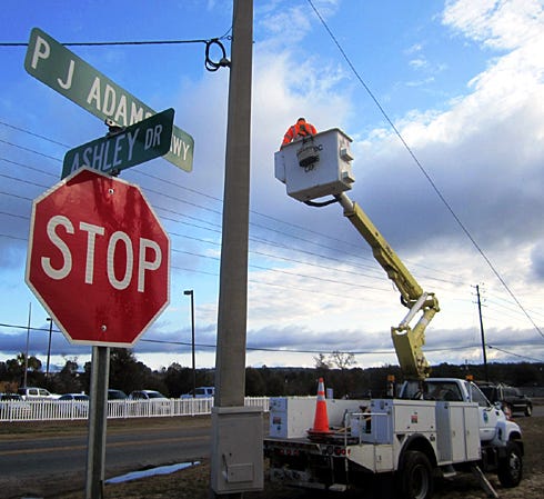An Okaloosa County Public Works crew prepares to raise the flashing emergency signal at the intersection of P.J. Adams Parkway, Villacrest and Ashley Drives.