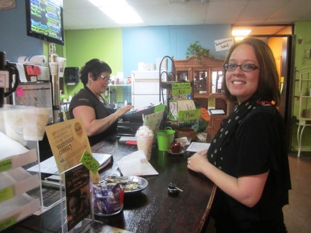 Ali Conlee orders one of one of her last Journey Java coffee drinks as owner Sandra Peters rings up the sale. The cafe will close April 25. "It's a disappointment," Conlee said.