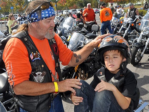 Bobby Pruette prepares his grandson, Lucas Reeves, 8, for the Toys for Kids motorcycle run.
