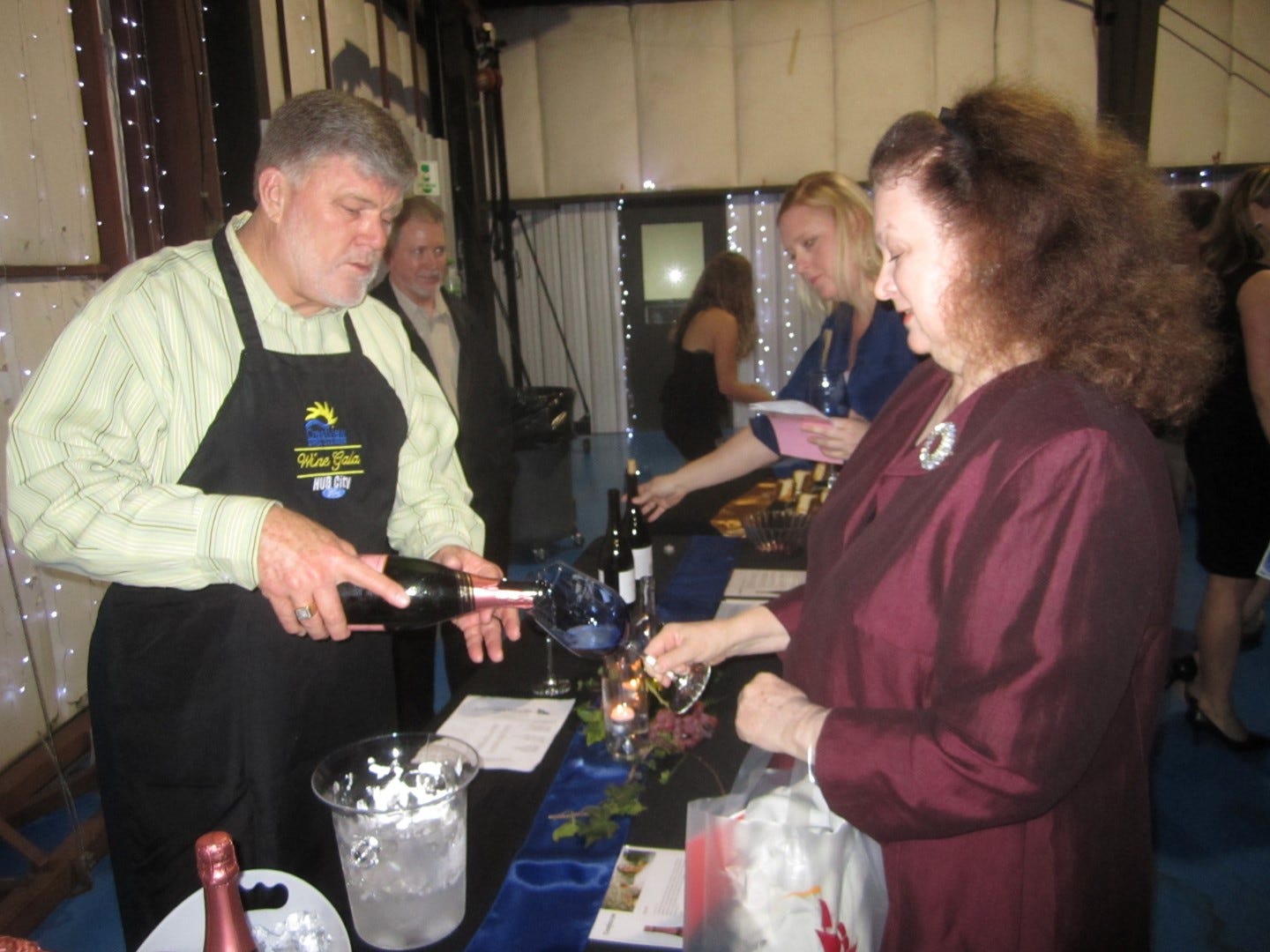 Volunteer sommelier Craig Yort pours a glass of sparkling wine for Amanda Lee Moore at the 2013 chamber of commerce Wine Gala.